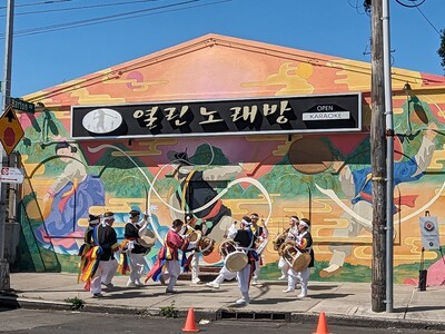 drummers in front of color and sound mural