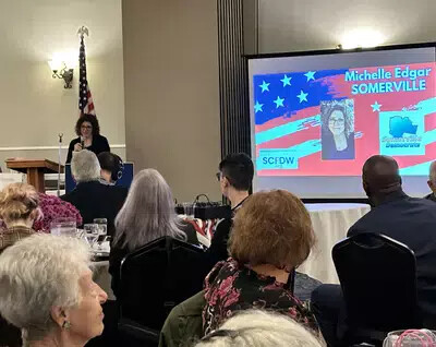 michelle edgar getting award with slide on screen and room of people