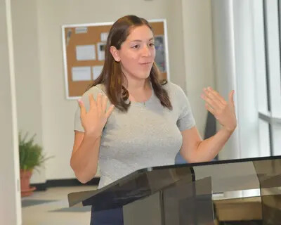 laura bacino signing at podium
