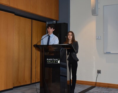 male and female student at podium
