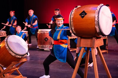 four taiko drummers with large drum
