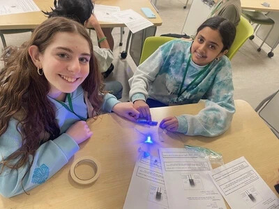 two girls at table with small light