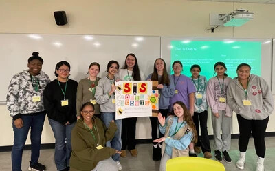 club members and girl scouts with poster