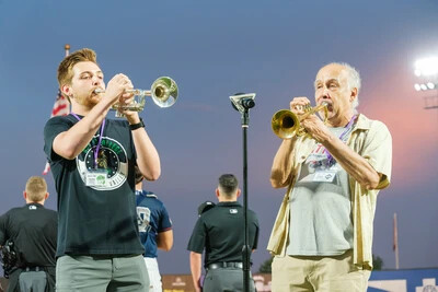2 trumpet players outside in the evening