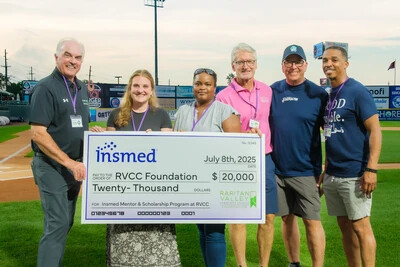 4 men and 2 women holding large check