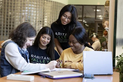 four students around laptop