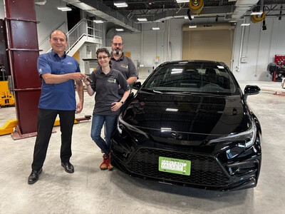 3 adults standing next to dark car in rvcc automotive shop