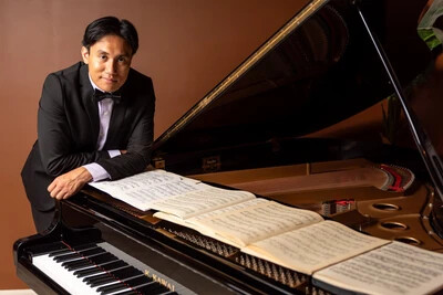 alinea leaning on piano
