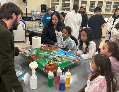 little girls in lab coats watching science experiments