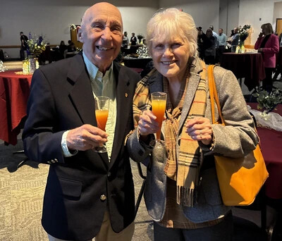 older couple holding cocktail style glasses with drinks