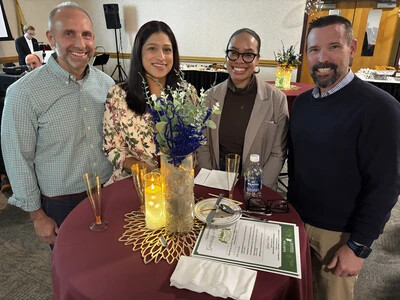 four people standing at table with centerpiece