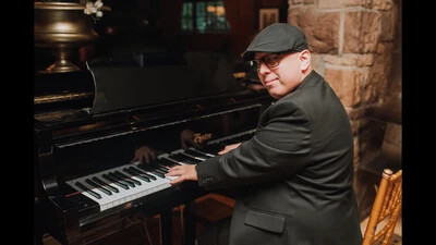 jeremy sweet at piano wearing cap