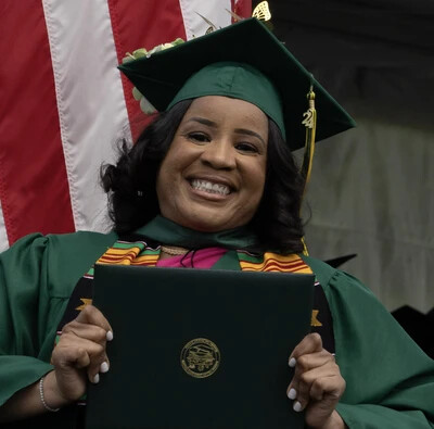 older grad holding diploma case