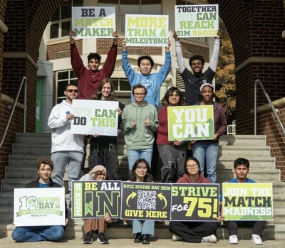 giving day photo outside with students holding signs