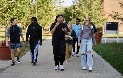 students outside walking by west building