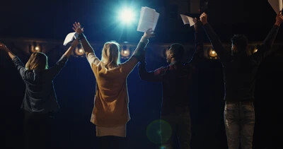 backs of actors bowing on stage