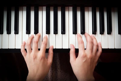 woman's hands on piano