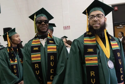 male grads in glasses and kente sashes