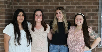 four student in front of brick wall at rvcc
