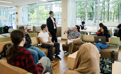 students sitting on couches with faculty member standing