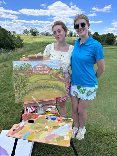 aria and becka on golf course with painting