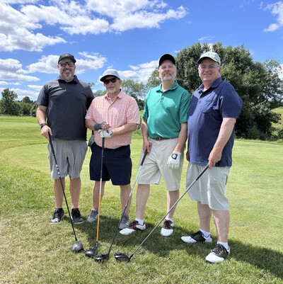 four male golfers on golf course