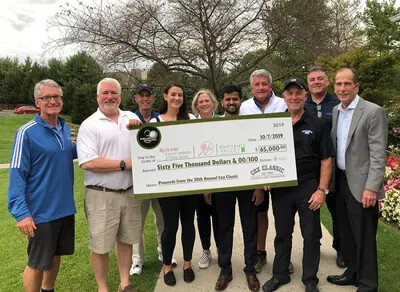 line of people holding giant check