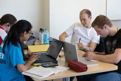 four students with laptops