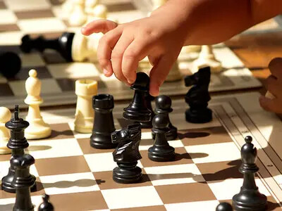 child's hand playing chess
