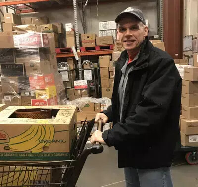 ronald gazaway wearing baseball hat and holding cart of food