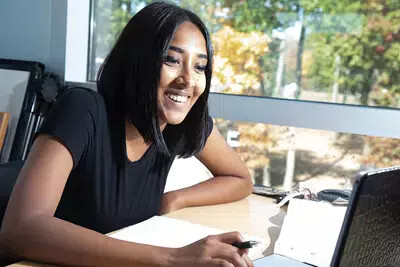 brown-haired female student working on laptop