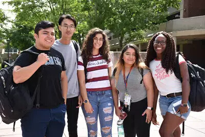 lineup of 5 students standing outside
