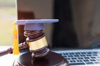 gavel with graduation cap on keyboard