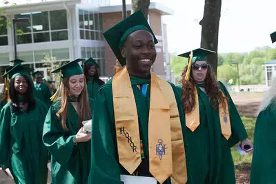 line of grads with one wearing honors stole