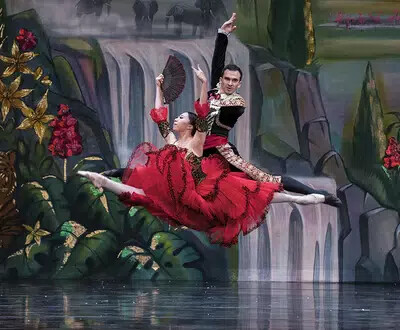 female and male ballet dancers doing splits in air