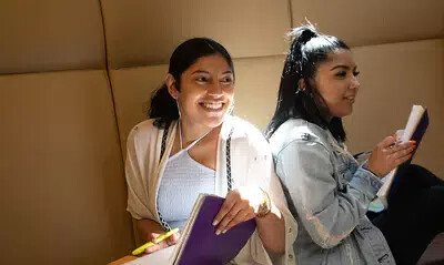 two females students sitting back to back