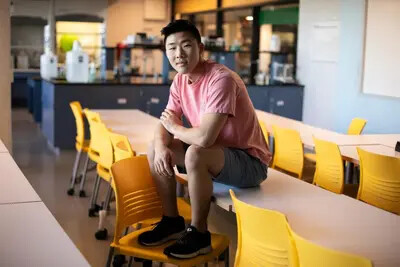 male students sitting on table with yellow chairs