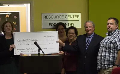 five people with large check
