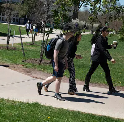 students walking outside with one wearing shorts