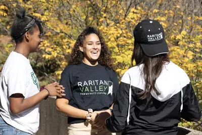 3 girls outside with girl in middle wearing rvcc tshirt