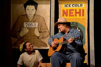 girl seated next to man playing guitar
