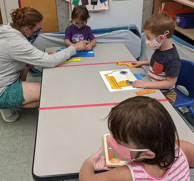 children and teacher at table