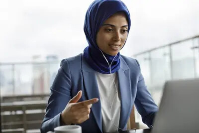 young woman in blue blazer on laptop