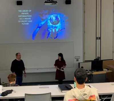 male professor standing next to female student with brown hair