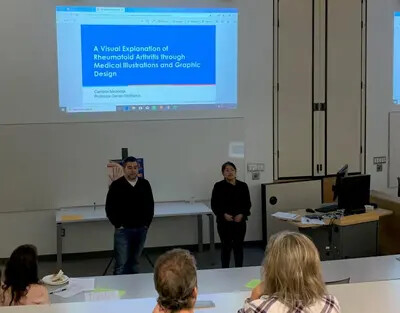 male professor standing next to female student in front of group