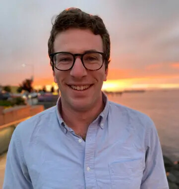 headshot of daniel solomon in blue shirt