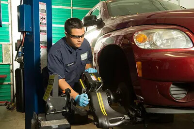 man in goggles working on car