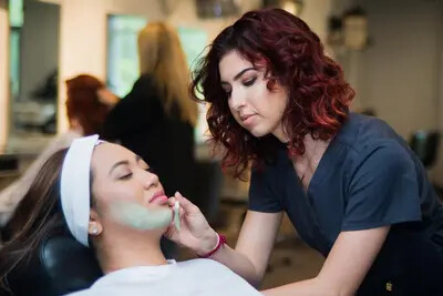 female student giving facial to another female students