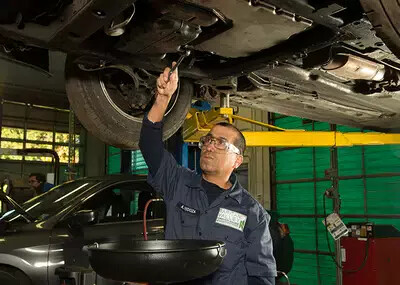 student working under raised car