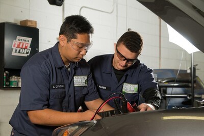 2 male students working on car